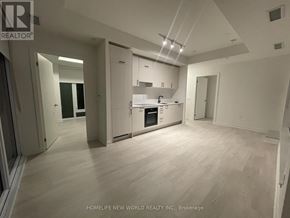 Toronto (Banbury-Don Mills) condo for rent - A spacious kitchen with white cabinets and a wooden floor.