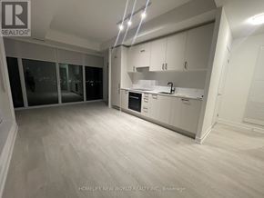 Toronto (Banbury-Don Mills) condo for rent - A spacious kitchen with white cabinets and a large window overlooking the city.