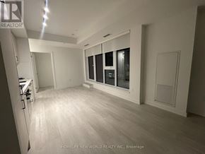 Toronto (Banbury-Don Mills) condo for rent - A spacious room with a kitchen area and a window with a view of a building.