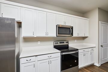 Waukee apartment for rent - A kitchen with white cabinets and appliances.