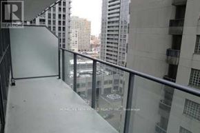 Toronto (Bay Street Corridor) condo for rent - A balcony with a glass railing overlooking a cityscape.