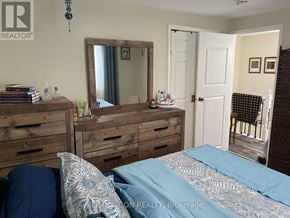 London South (South X) apartment for rent - A bedroom with a bed, dresser, and mirror.