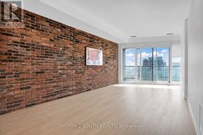 Toronto (Dufferin Grove) condo for rent - A room with a brick wall and wooden flooring.