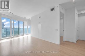 Toronto (Dufferin Grove) condo for rent - A spacious room with a view of the cityscape through the windows.