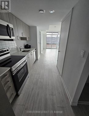 Toronto (Yorkdale-Glen Park) condo for rent - A modern kitchen with a view of the backyard.