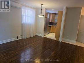 Toronto (Junction Area) apartment for rent - A room with wooden floors and a window with curtains.