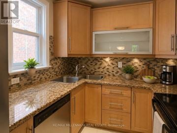 Toronto (Junction Area) apartment for rent - A kitchen with wooden cabinets and a granite countertop.