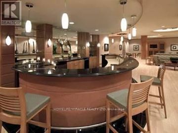 Toronto (Islington-City Centre West) condo for rent - A well-lit, modern kitchen with a curved island and wooden chairs.