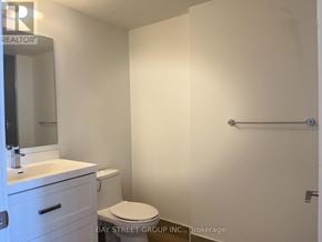 Toronto (Church-Yonge Corridor) condo for rent - A white bathroom with a toilet, sink, and mirror.