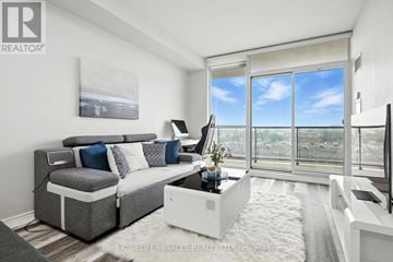 Toronto (Wexford-Maryvale) condo for rent - A living room with a grey couch and a large window.