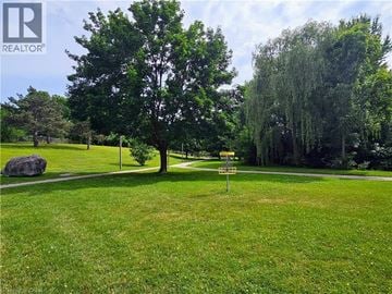 Cambridge townhouse for rent - A green grassy field with a tree and a sign.