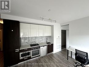 Toronto (Church-Yonge Corridor) condo for rent - A modern kitchen with dark wood floors and white walls.