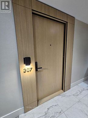 Toronto (Englemount-Lawrence) condo for rent - A wooden door with the number 307 on it.