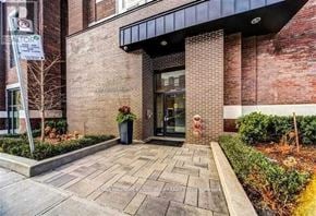 Toronto (The Beaches) condo for rent - A brick building with a black awning and a glass door.