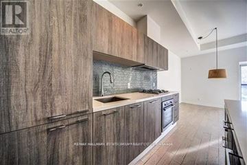 Toronto (The Beaches) condo for rent - A modern kitchen with wooden cabinets and a stainless steel backsplash.