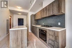 Toronto (The Beaches) condo for rent - A modern kitchen with wooden cabinets and a stone backsplash.