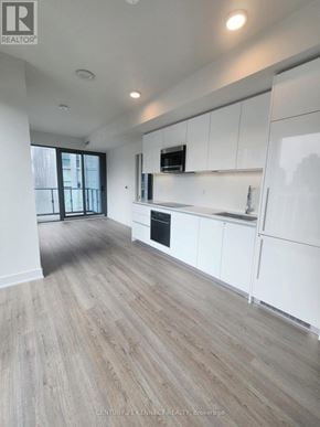 Toronto (Annex) condo for rent - A spacious kitchen with white cabinets and a wooden floor.