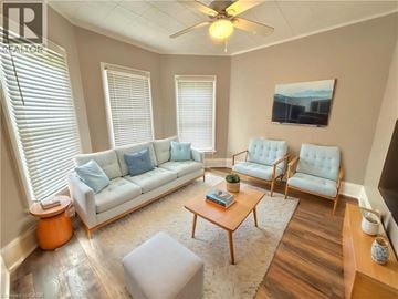 Brantford apartment for rent - A living room with a white couch, a wooden coffee table, and a painting on the wall.