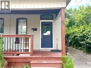 Brantford apartment for rent - A house with a blue door and a sign that says REALTOR.