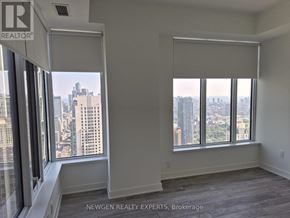 Toronto (Annex) condo for rent - A room with a view of the cityscape through large windows.