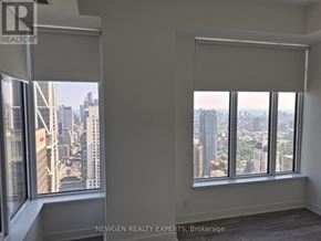 Toronto (Annex) condo for rent - A room with a view of the cityscape through large windows.