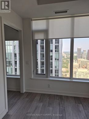 Toronto (Annex) condo for rent - A room with a view of the city through large windows.