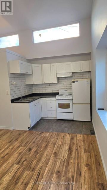 Toronto (O'connor-Parkview) apartment for rent - A kitchen with white cabinets and a wooden floor.