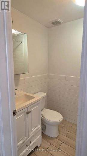 Toronto (O'connor-Parkview) apartment for rent - A white toilet in a small bathroom with a sink and a mirror.