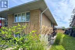 Oshawa (Centennial) apartment for rent - A house with a green lawn and a flag on the left.