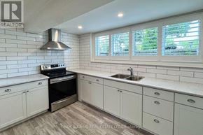 Oshawa (Centennial) apartment for rent - A kitchen with white cabinets and a stove top oven.