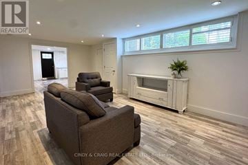 Oshawa (Centennial) apartment for rent - A living room with a brown couch and a white cabinet.