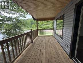 Heyden apartment for rent - A wooden deck with a view of trees and a body of water.