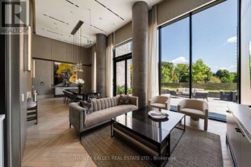 Toronto (Forest Hill South) condo for rent - A modern living room with a glass table and a large window.