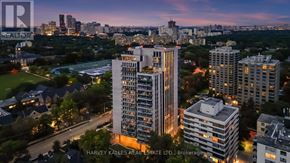 Toronto (Forest Hill South) condo for rent - A cityscape at dusk with a prominent building in the foreground.