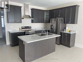 Orillia apartment for rent - A modern kitchen with dark grey cabinets and a central island.