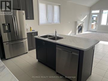 Orillia apartment for rent - A kitchen with a sink and refrigerator in a house.