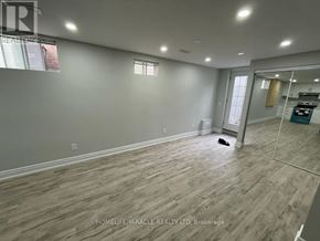 Brampton (Sandringham-Wellington) apartment for rent - A room with wooden flooring and a large mirror on the wall.