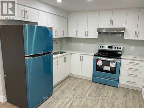 Brampton (Sandringham-Wellington) apartment for rent - A kitchen with a blue fridge and white cabinets.