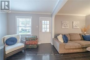 St. Catharines (Facer) apartment for rent - A living room with a couch, a window, and a door.
