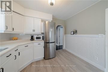 St. Catharines (Facer) apartment for rent - A kitchen with white cabinets and a stainless steel refrigerator.