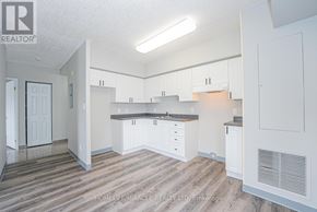 Waterloo multi-family for rent - A kitchen with white cabinets and a wooden floor.