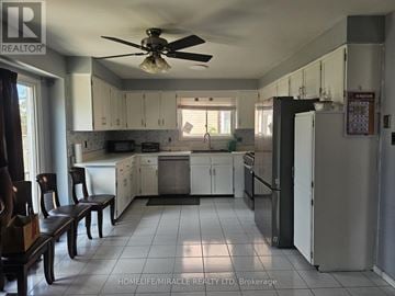 Hamilton (Gilkson) apartment for rent - A kitchen with white cabinets and a black fridge.