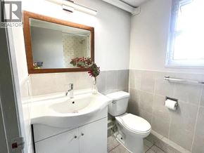 Vancouver apartment for rent - A white bathroom with a sink, toilet and mirror.