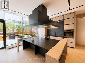 Toronto (North St. James Town) condo for rent - A modern kitchen with a large island and a stainless steel range hood.