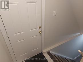 Toronto (Rouge) apartment for rent - A white door with a gold handle is in the foreground of this image.