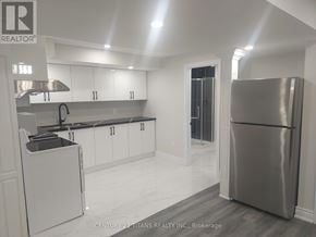 Toronto (Rouge) apartment for rent - A modern kitchen with white cabinets and a stainless steel refrigerator.