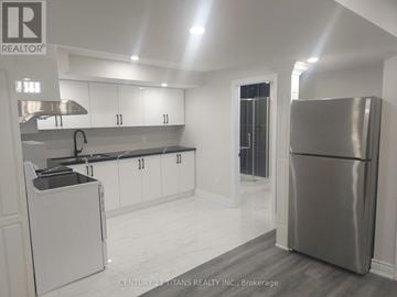 Toronto (Rouge) apartment for rent - A modern kitchen with white cabinets and a stainless steel refrigerator.