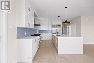 Ottawa apartment for rent - A modern kitchen with white cabinets and a marble island.