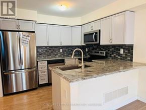 Toronto (Clairlea-Birchmount) townhouse for rent - A kitchen with white cabinets and a granite countertop.