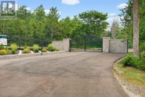 Caledon apartment for rent - A driveway leads to a gated entrance with a brick pillar on either side.